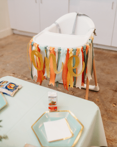 High chair decorated with ribbon tassels and one for first birthday celebration