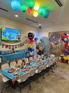 kids party room decorated with paw patrol theme. custom balloons and set up for 20 kids aged 4