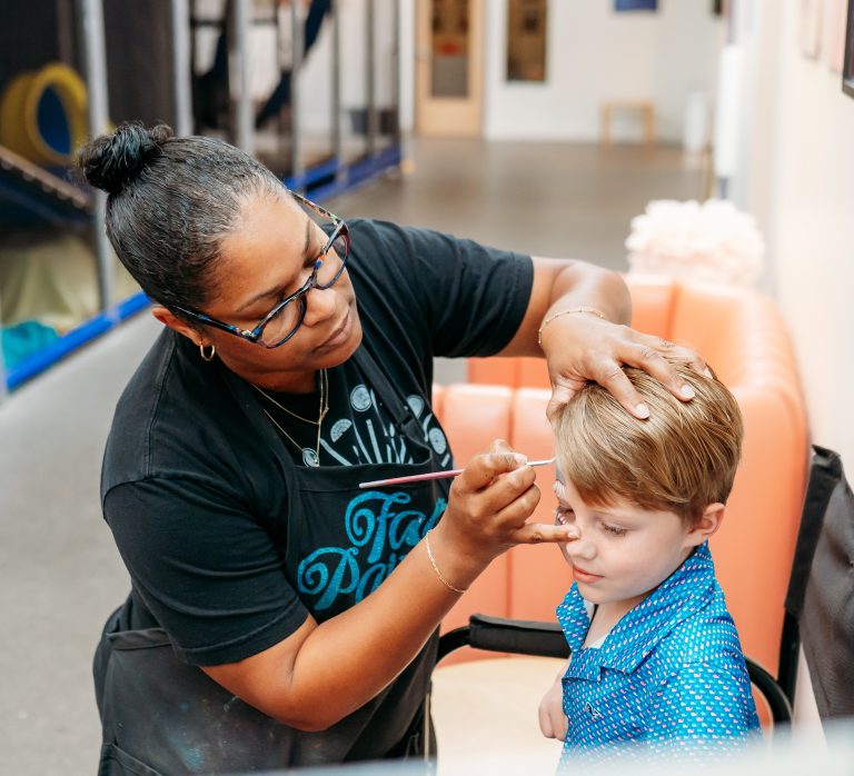 Five Year Old boy getting face painted at birthday party at indoor playground in Sandy Springs, GA