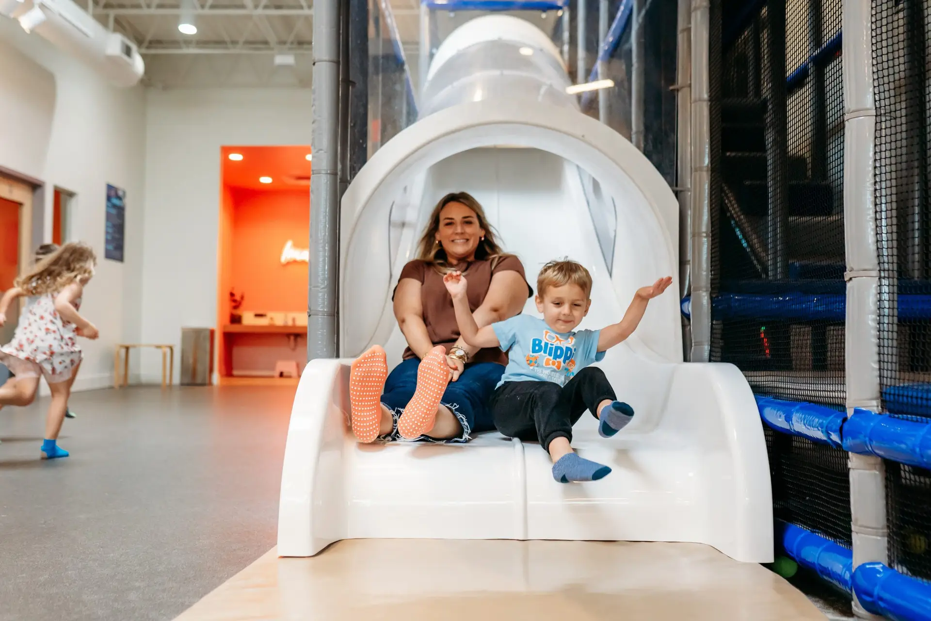 Mom and son sliding together at Ready Set Fun indoor playground in Sandy Springs