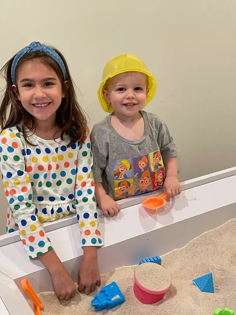 Young girl and toddler boy playing together at the Imagination Sandbox at Ready Set Fun in Sandy Springs