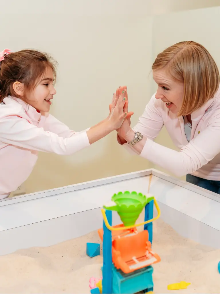 Mother and daughter high-fiving in the Imagination Sandbox at Ready Set FUN in Sandy Springs.