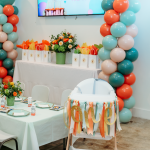 high chair decorated for first birthday party in party room