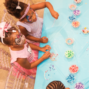 Party guests make friendship bracelets at a kids birthday party