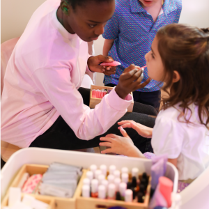 Sparkle attendant applying lip gloss to birthday girl's lips